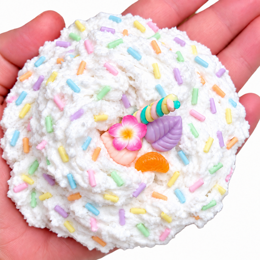 Piña Colada snow fizz slime held in a hand with pastel sprinkles and tropical charms
