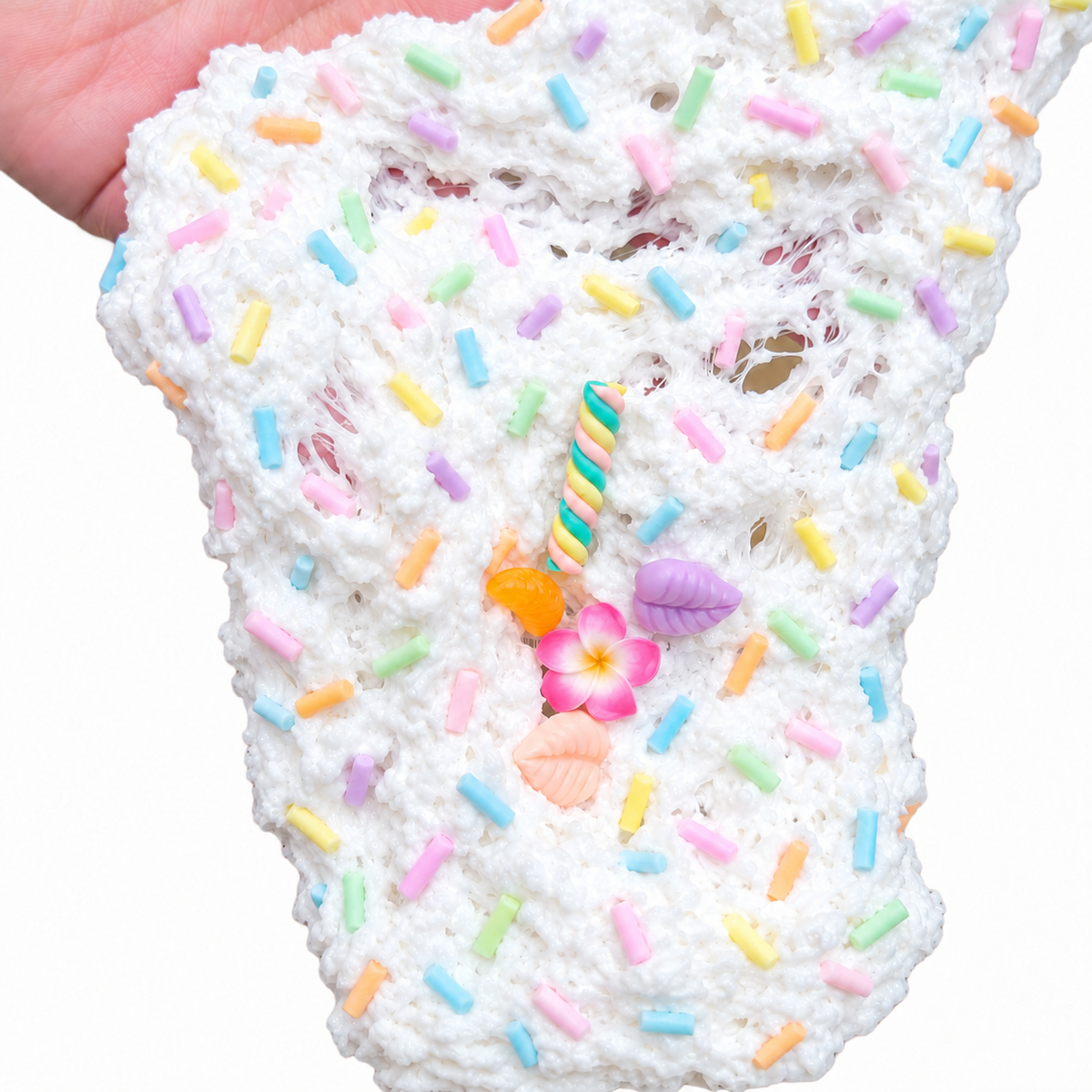 Piña Colada snow fizz slime stretched to show its crunchy texture and pastel sprinkles