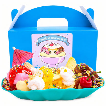 Banana Split DIY scented handmade slime kit with butter slime, clay ice cream scoops, toppings, sprinkles, banana boat, squishy toy, and blue gift box.